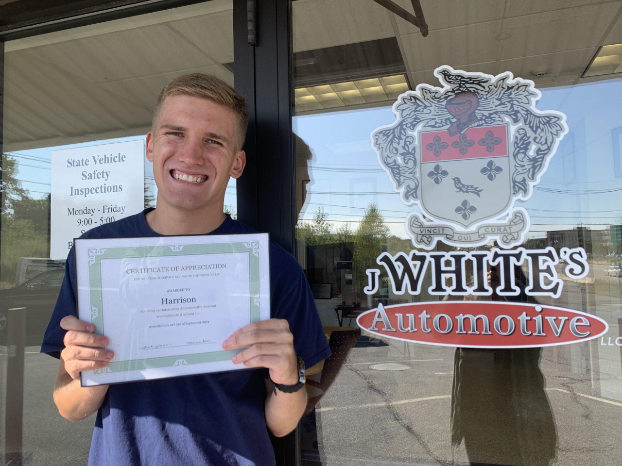 Harrison Shaffer proudly showing off his 1 year of employment certificate from J. White's Automotive.